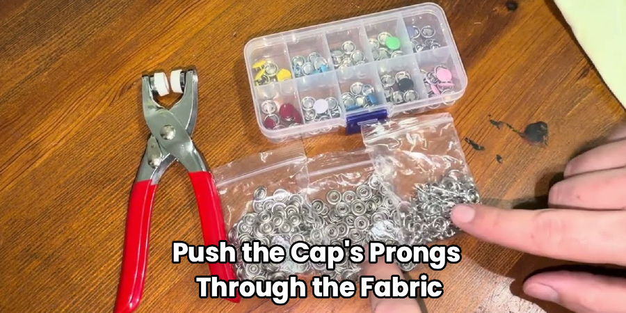 Push the Cap's Prongs 
Through the Fabric